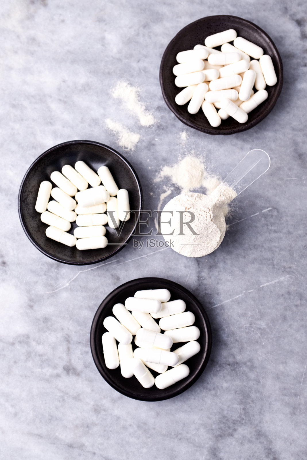 乳清蛋白,水解膠原I型,l -脯氨酸和l -賴氨酸膠囊勺。補(bǔ)充膠原蛋白的生產(chǎn)。明亮的石頭背景。直接上圖。副本的空間。